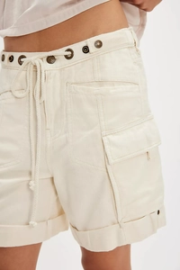 Détail du short cargo beige avec cordon à la taille, œillets en métal et coton texturé