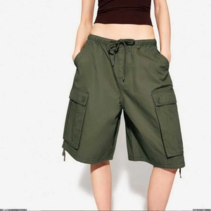 Detail of army green cargo shorts featuring an elastic drawstring waist and large flap pockets