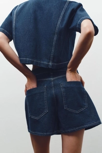 Detail of dark blue denim set featuring white contrast stitching on back pockets