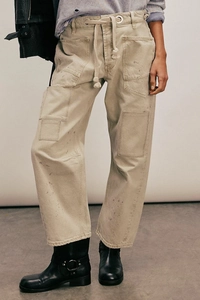 Détail du pantalon cargo kaki avec taches de peinture et cordon de serrage en coton crème