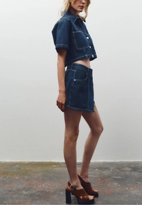 Detailed view of high waist denim skirt with contrast white stitching and cotton fabric