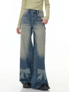 Detail shot of vintage washed blue wide-leg jeans featuring a large blue bow print design