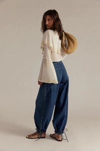 Vista intera di pantaloni denim retrò abbinati a top bianco con maniche a campana