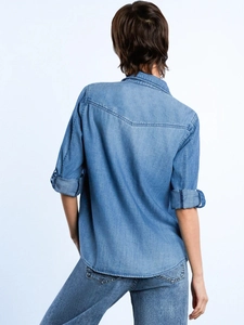 Back view of a loose-fit light blue washed denim shirt with V-shaped yoke stitching