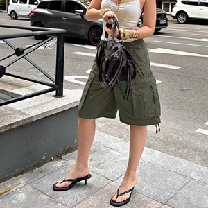 Close-up of army green cargo shorts featuring side pockets and adjustable drawstring hem