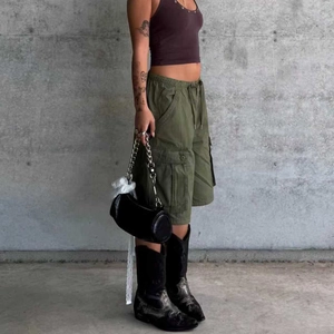 Detail of military green cargo shorts featuring elastic drawstring waist and side pockets