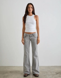 Detail of light gray low-rise flare jeans paired with a white ribbed crop tank top