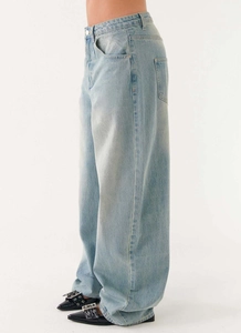 Detail view of high-waist wide-leg denim jeans in light blue wash with loose fit