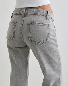Detail view of light grey denim texture with back pockets and high-quality stitching detail