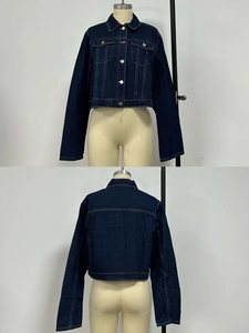 Détail d'une veste en jean bleu foncé avec col classique et coutures contrastées blanches