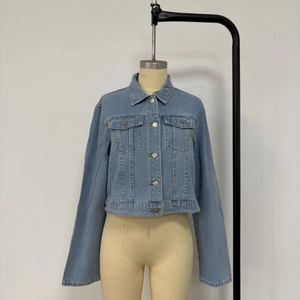Détails de la veste en jean bleu clair avec deux poches à rabat et boutons métalliques