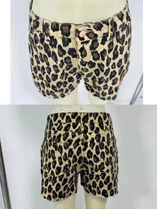 Detailed close-up of leopard print denim shorts with frayed edges and high waist design