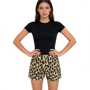 Close-up of high-waisted leopard print denim shorts with raw hem edges and black tee