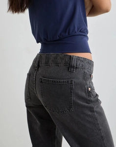 Close-up of the slim-fit washed black flare jeans with back pockets and rose gold rivets