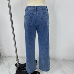Detail view of high-waist wide-leg jeans showing back pockets and washed denim texture