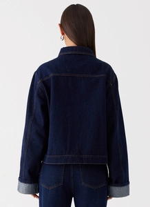 Détail de la veste en jean bleu foncé avec coutures contrastées et empiècement au dos