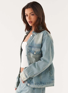 Detail of light blue denim jacket featuring vintage wash, lapel collar, and metal buttons