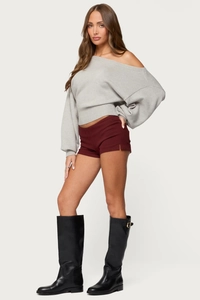Slim fit gray off-shoulder knit sweater with burgundy shorts and tall black boots