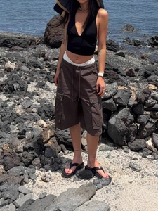Women's dark brown cargo shorts with drawstring waist and pockets in outdoor setting