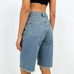 Detail view of frayed hem and back pockets on light blue high-waist denim Bermuda shorts