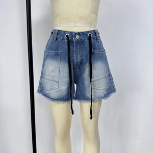 Detail of light blue washed denim shorts with drawstring waist and frayed hem edges