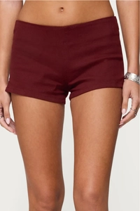Close-up of slim-fit wine red denim shorts with side invisible zipper and low-rise cut