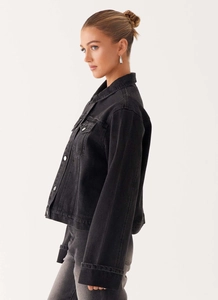 Détail d'une veste en jean noir délavé avec revers classiques et boutons en métal