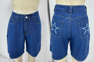 Vue détaillée du short en jean bleu foncé avec broderie étoile blanche sur les poches arrière