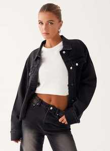 Détail d'un ensemble veste en jean oversize gris foncé et jean à texture délavée