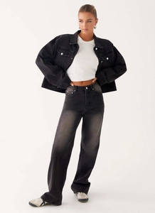 Gros plan sur la veste en jean rétro noire et le jean gris taille haute sur modèle