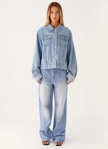 Gros plan d'une veste en jean bleu clair avec boutons métalliques et col classique