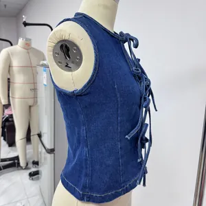 Dettaglio dell'allacciatura incrociata su un gilet in denim blu scuro aderente su manichino