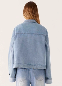Vue détaillée de la texture d'une veste en jean bleu clair avec coutures et revers