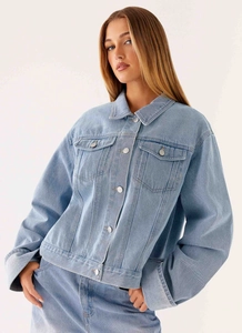 Détail d'une veste en jean surdimensionnée bleu clair avec col classique et poches à rabat