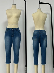 Detail view of washed denim capri pants for women with raw hem and distressed finish