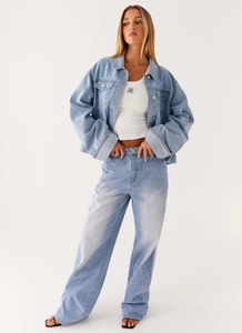 Détail d'un ensemble en jean bleu clair avec pantalon large et veste courte ajustée