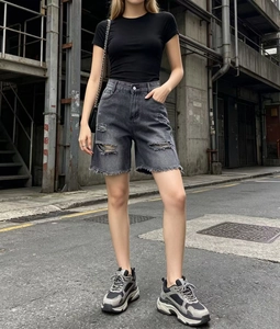 Dettaglio di pantaloncini di denim grigio scuro a vita alta con bordi sfrangiati e strappi