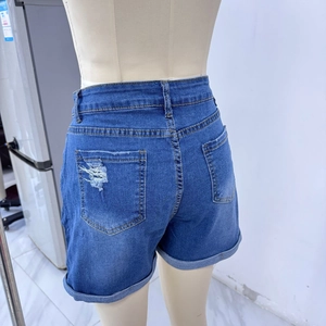 Detail view of denim shorts featuring distressed back pockets and fixed rolled hems