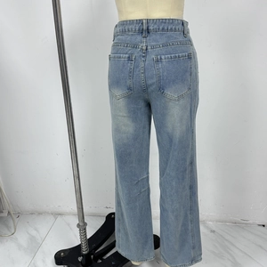 Detail view of the back pockets and waist design of light blue high waist denim pants