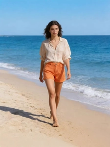 Women summer outfit featuring a beige linen shirt and high-waist orange denim shorts