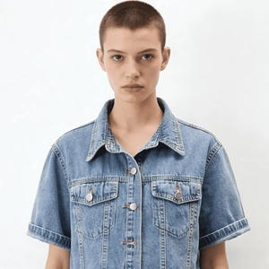 Details des hellblauen Crop-Denim-Oberteils mit Umlegekragen und silbernen Knöpfen