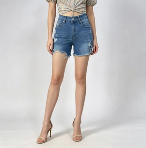 Détails d'un short en jean taille haute avec déchirures usées et ourlet effiloché à franges
