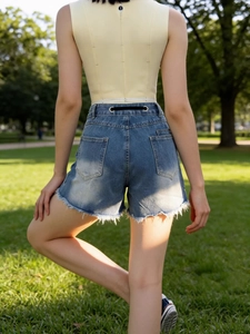 Women's high waist washed denim shorts with ripped details and raw hem in summer outdoor
