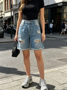 Dettaglio di pantaloncini in denim azzurro con strappi ed effetto orlo sfrangiato