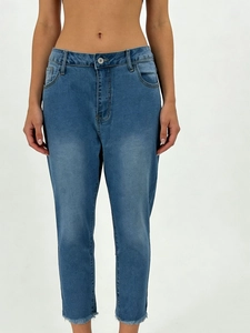 Detailed view of women's stretch skinny jeans with faded whiskers and frayed raw hems