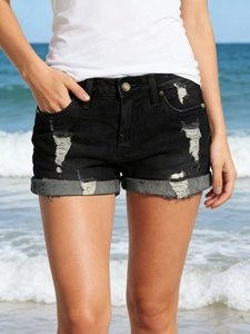 Détail de short en jean noir usé avec déchirures et ourlets repliés élégants