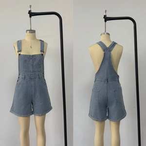 Detailed front and back view of light blue denim dungaree shorts with cargo pocket and cuffs