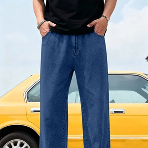 Relaxed fit blue tencel denim jeans for men styled against a vintage yellow car background