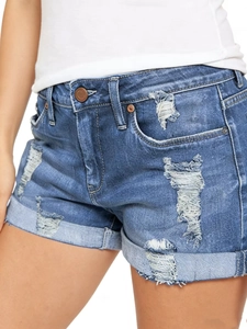 Détail d'un short en jean avec déchirures stylées et motifs de moustaches délavées