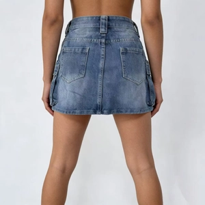 Dettaglio delle tasche posteriori e della trama denim lavato di questa minigonna cargo